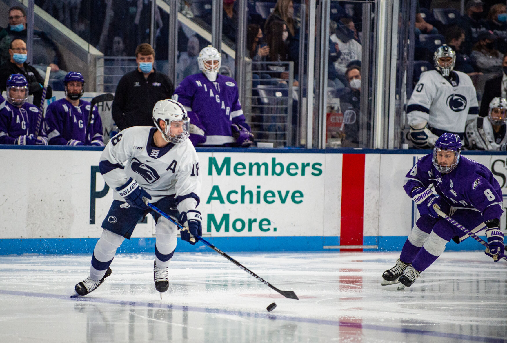 Clayton Phillips (18) defends puck against Walker Sommer (8) at game against Niagara